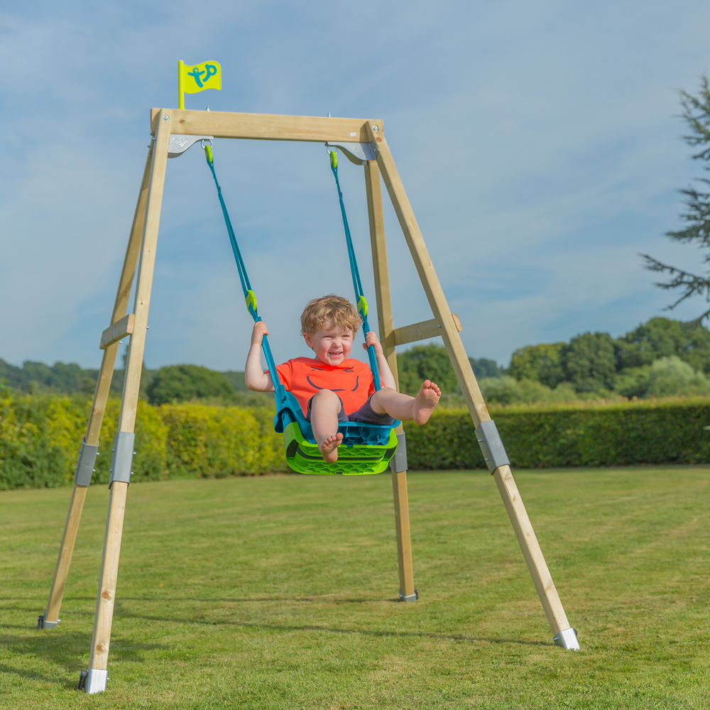 Child playing on single wooden swing set
