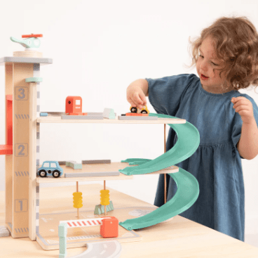 Child playing with wooden car garage