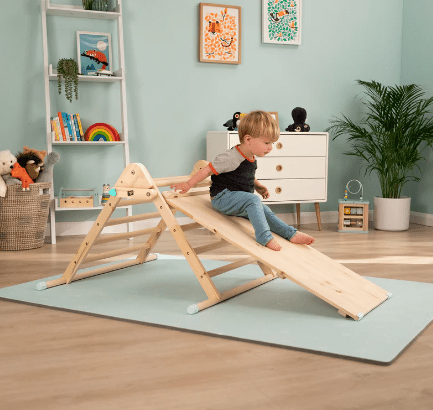 Child playing on the Pikler triangle
