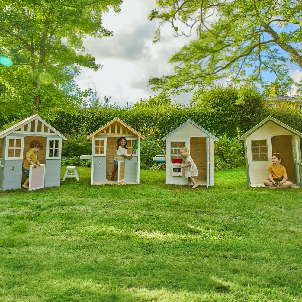 Children playing in wooden cottage playhouses