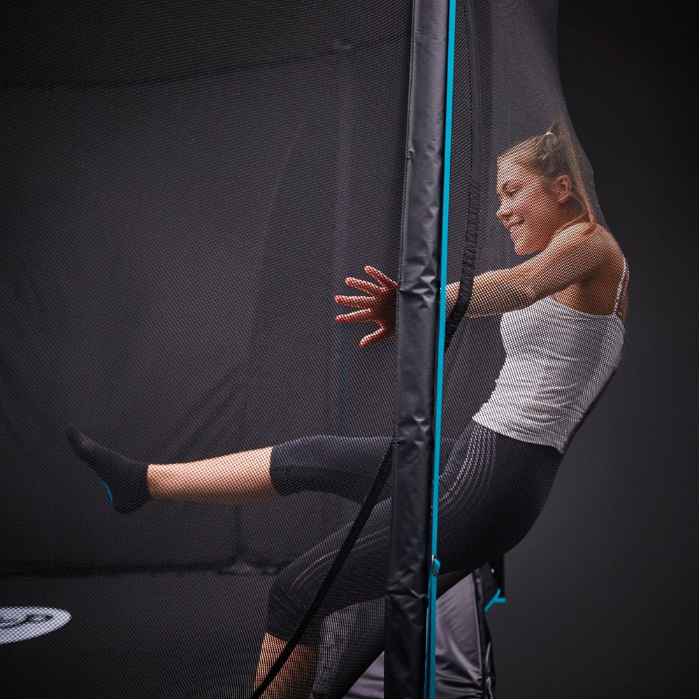 Girl jumping into trampoline enclosure