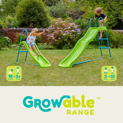 Two children play on TP Toys TP Small to Tall Growable Slide in a grassy garden. The adjustable outdoor slide suits ages 18 months–3+ years for one version and 3–10 years for the other, making it fun as your child grows.