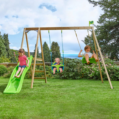 Three children play on the TP Toys Forest Multiplay Double Wooden Swing Set with Quadpod, Roped Rapide seat & Slide—one slides, another swings in the Quadpod baby seat, and the third enjoys the green swing—all outdoors.