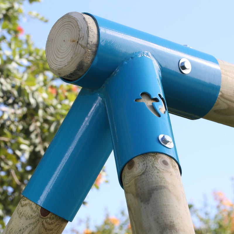 Close-up of the TP Toys TP Knightswood Double Wooden Swing Set With Glide Ride, joined with blue metal brackets and bolts, featuring a bird-shaped cutout, outdoors against a backdrop of blue sky and trees.
