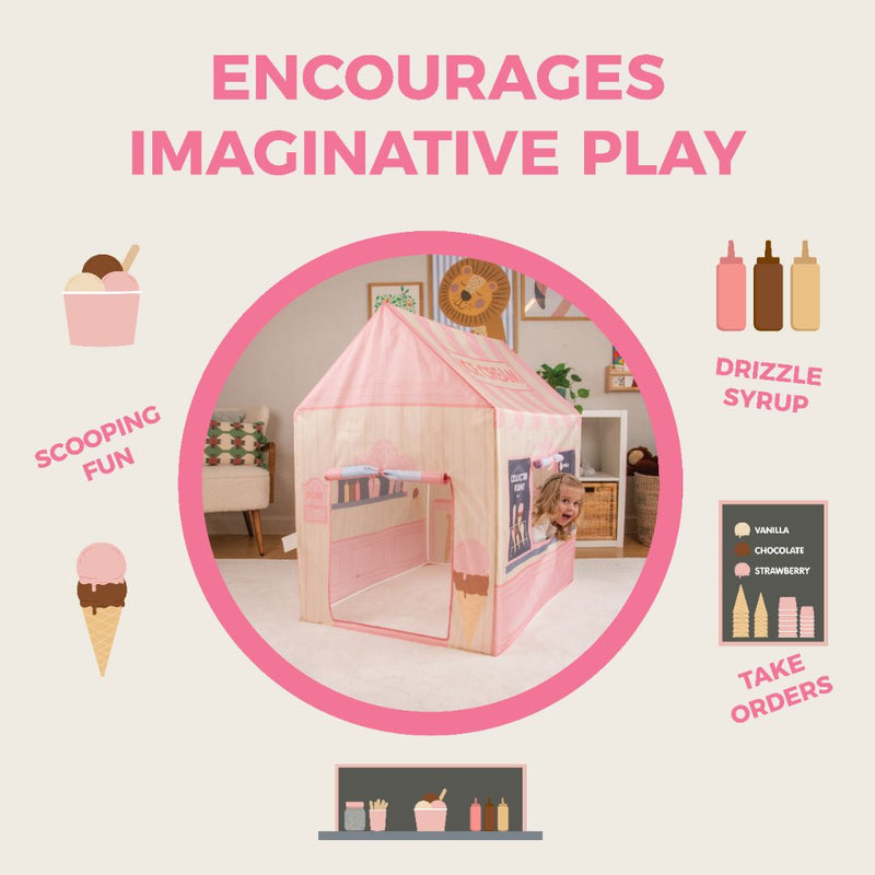 A child peeks out from the TP Toys Activo Ice Cream Shop Play Tent, a pink playhouse decorated with icons and text that encourage imaginative play.