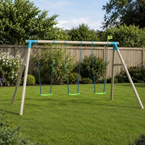 The TP Toys TP Sherwood Triple Wooden Swing Set – PEFC certified, featuring three green roped swing seats, is set up on a neatly mowed lawn in a backyard bordered by bushes, flowers, and a wooden fence.