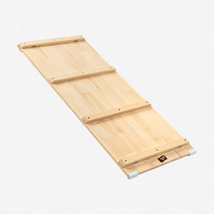 The TP Active-Tots Pikler Style Wooden Climbing Bridge and Slide by TP Toys, crafted from FSC® certified wood, is inspired by Montessori principles and features three horizontal support bars along with rubber edge protectors at one end. This versatile piece of indoor play equipment is showcased against a light background.