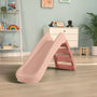 A TP Toys PalPlay Pink Blush Plastic 4ft Folding Slide is set on a light wooden floor in a playroom filled with toys, shelves, and framed pictures on the walls.
