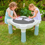 Two young children play with colored pencils on the Palplay Misty Sky Sand & Water Play Table by TP Toys in a garden, with flowers in the background.