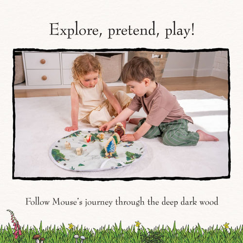 Two children sit on a white rug, playing with the TP Toys Gruffalo Play Set with Wooden Characters on a round illustrated play mat in a bright, tidy room.