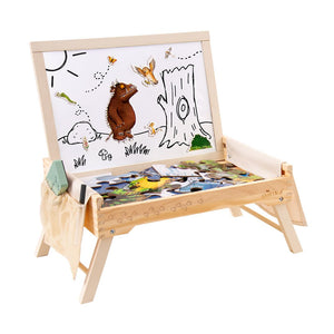 The Gruffalo Wooden Creative Station by TP Toys is an FSC® certified wooden activity table with a dry-erase board featuring a bear illustration, a magnetic puzzle in progress, and art supplies on the side—perfect as a creative toy for imaginative play.