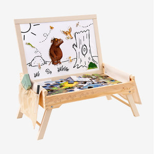 The TP Toys The Gruffalo Wooden Creative Station – FSC® certified, features a wooden activity table with a Gruffalo-themed drawing board and a partially completed magnetic puzzle arranged on the tray, along with a cloth and book at the side—a perfect children’s whiteboard to inspire imaginative play.