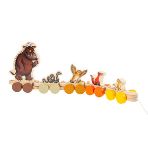 The Gruffalo Wooden Pull Along Character Set by TP Toys is an FSC® certified wooden toy featuring colorful wheels and painted animal figures—including a monster, snake, owl, fox, and mouse—all linked together in a row for imaginative play.