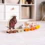The Gruffalo Wooden Pull Along Character Set - FSC® certified by TP Toys features painted animal figures—including the Gruffalo, snake, owl, fox, and mouse—perfect for imaginative play. Resting on a light-colored carpet near shelves and baskets, this charming set not only delights as a pull-along toy but also works beautifully as a stacking character set to encourage creativity and fine motor skills.