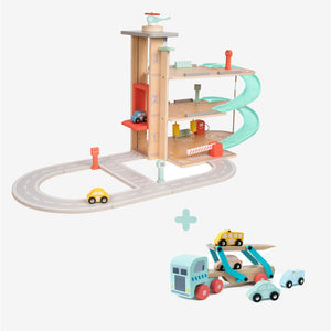 The TP Toys Owl & Fox Wooden Multi-storey Garage with Vehicle Transporter—crafted from FSC® certified wood—features cars, a spiral ramp, lift, and road for pretend play. Shown with a toy car carrier truck and cars beneath, this Montessori-inspired set encourages imaginative play and develops fine motor skills.