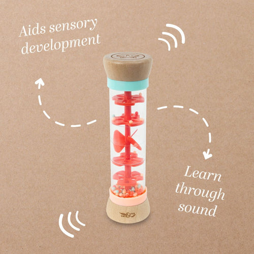The Owl & Fox Wooden Rainmaker - FSC® certified by TP Toys is a clear sensory tube with red spinning elements and beads, designed to aid sensory development and encourage learning through sound.
