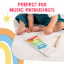 A child sits on a white carpet playing the colorful Grow With Peppa Pig Wooden Xylophone by TP Toys. Text above says: Perfect for early musical skills and young music fans.