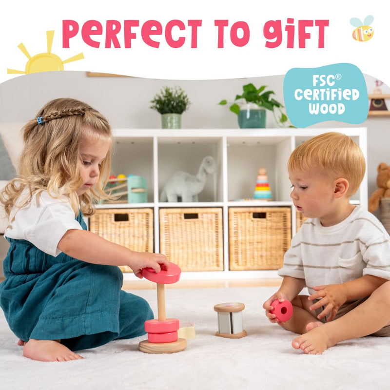 Two young children play with the TP Toys Grow with Peppa Pig Wooden Roller Rattle and Topple Tower Set on the floor of a bright room with shelves and baskets. Perfect to gift and made from FSC certified wood.