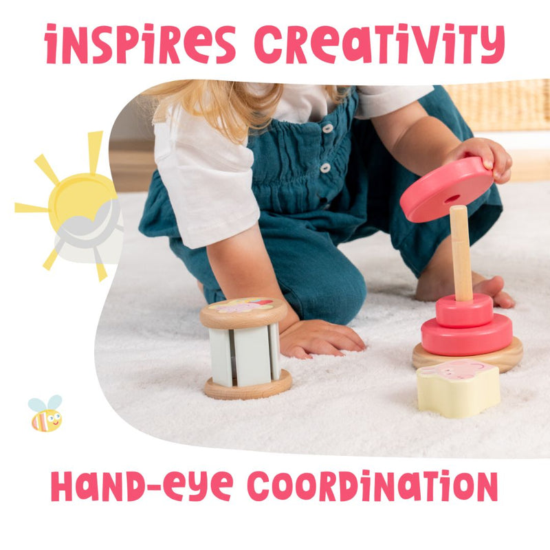 A child plays on a white carpet, stacking colorful rings from the TP Toys Grow with Peppa Pig Wooden Roller Rattle and Topple Tower Set, inspiring creativity and hand-eye coordination.