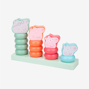 Four delightful cartoon pig character figures—including Peppa Pig—stand atop colorful, wooden ring stacker posts mounted on a rectangular base and arranged from tallest to shortest, left to right. The Grow with Peppa Pig Wooden Family Ring Stacker by TP Toys is perfect for developing fine motor skills.