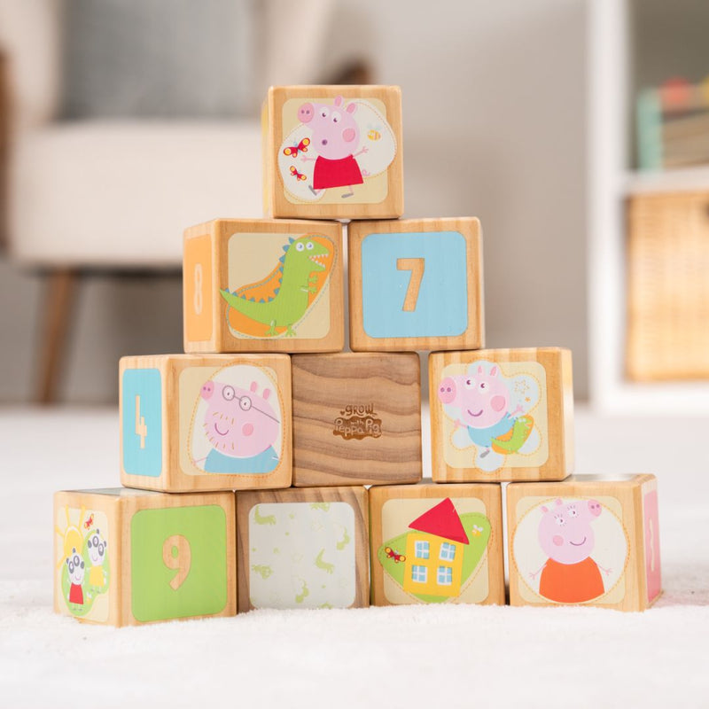 The TP Toys Grow with Peppa Pig 10 Piece Wooden Block Set features numbered blocks with cartoon animals and houses—ideal counting toys for playful learning on any surface.