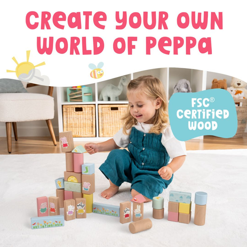 A young child sits on the floor building towers with the TP Toys Grow with Peppa Pig 80 Piece Wooden Block Set, made from FSC Certified Wood—perfect for inspiring creativity and building fine motor skills.