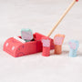 The TP Toys Grow with Peppa Pig Wooden Push Along Family Car features four colorful wooden character pegs and a wooden mallet, shown here on a light carpeted surface.