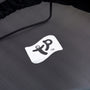 A close-up of the TP Toys Genius® 8ft Round Trampoline mat shows a white square logo with stylized black lettering and trademark symbol, emphasizing the trampoline's safety features.