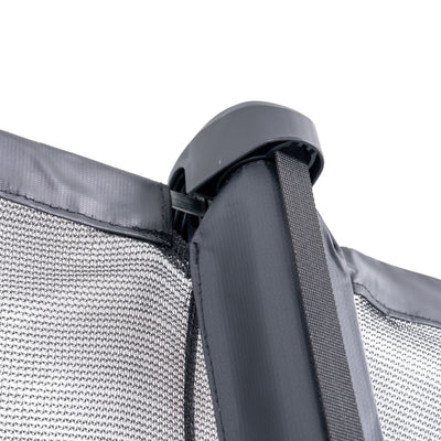 Close-up of the corner of a black mesh privacy screen attached to a vertical metal pole with a plastic cap, designed for safety on the TP Toys 12ft Infinity Round Trampoline.