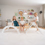 Three children play on the TP Toys TP Active-Tots Pikler Style Three in One Playset—FSC® certified—in a bright living room decorated with animal-themed art and toys.