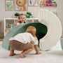 Two young children play with the TP Toys TP Active-Tots Pikler Style Rainbow Arch Playset, developing gross motor skills in a bright room featuring animal-themed artwork and a bookshelf.
