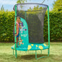 A young girl stands at the entrance of a TP Toys Bluey UP 4.5ft Junior Trampoline with a safety net and zip-free entry, set outdoors on a grassy lawn.
