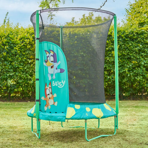 The Bluey UP 4.5ft Junior Trampoline by TP Toys is a small green trampoline with zip-free entry and a safety net, featuring Bluey and Bingo on the side panel, set up outdoors on grass.