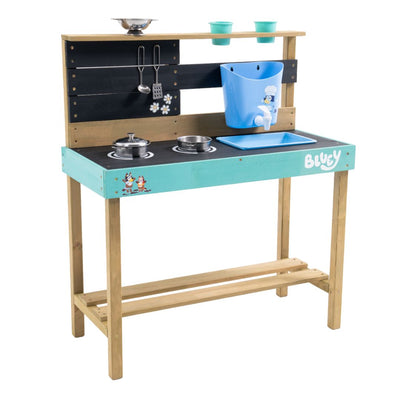 The TP Toys Bluey Wooden Mud Kitchen - FSC® certified features a stovetop, utensils, blue sink, shelves, and Bluey branding. This garden playset includes pots and cups on a black and blue countertop for creative outdoor fun.