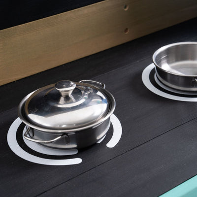 Two metal pots (one lidded) sit on a black stove with white burner marks—ideal for enhancing outdoor play with the Bluey Wooden Mud Kitchen by TP Toys, FSC® certified, perfect for imaginative garden fun.