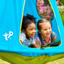 Two children smile and play inside the TP UFO Den & Climbing Frame Blue Edition by TP Toys, a bright blue hanging tent outdoors surrounded by greenery—an enchanting space that inspires kids’ imaginations during outdoor play.