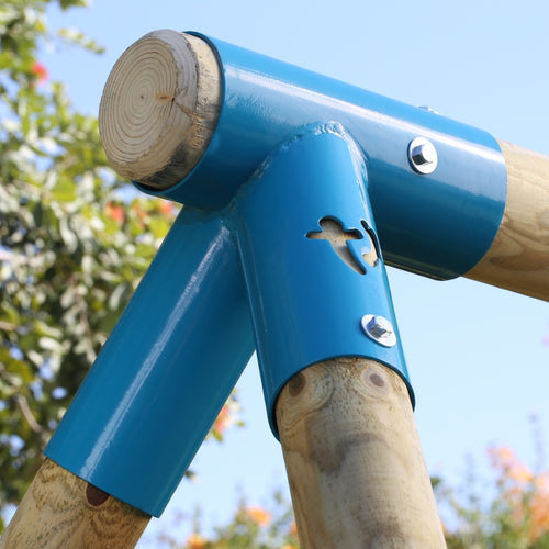 Close-up of the TP Toys TP Sherwood Single Wooden Swing Set with Bluey Quadpod—PEFC certified—featuring blue metal joints and bolts, set outdoors among trees and sky in the background.