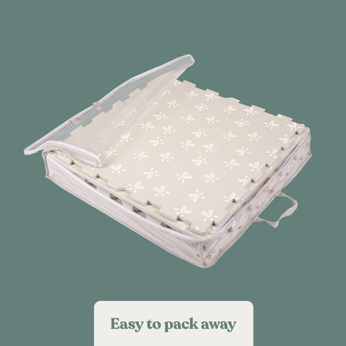 The TP Toys TP Active-Tots Safety Play Mat is a foldable, non-toxic foam mat with handle and clear cover, featuring a simple white pattern on beige. Ideal for toddler play areas and easy to pack away.