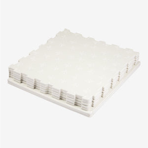 Neatly arranged on a white surface, the TP Active-Tots Safety Play Mats from TP Toys feature interlocking white foam tiles with a subtle pattern, offering a comfortable and safe foundation for active little ones.