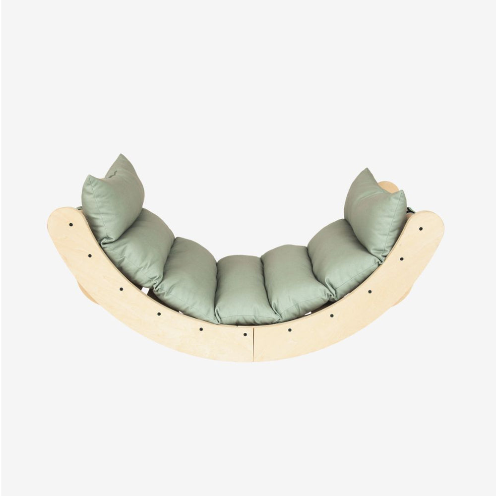 TP Toys TP Active-Tots Sway Wooden Rocker with Cushion – FSC® certified, featuring a curved wooden design with a light green cushion and four pillows, photographed against a plain white background.