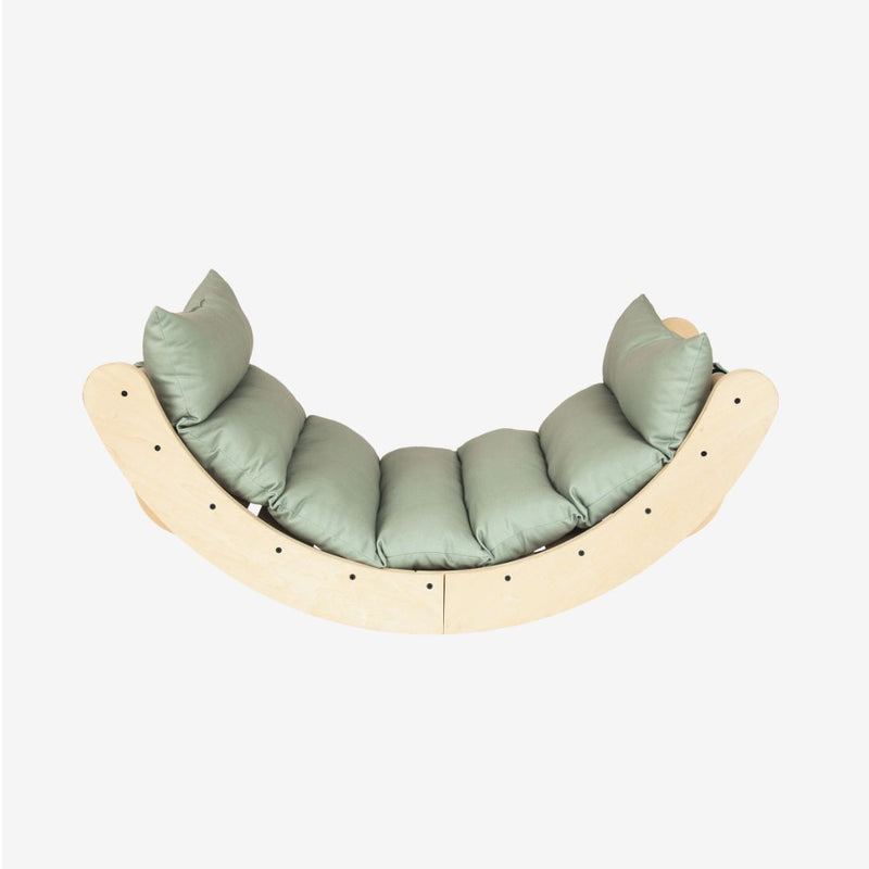 TP Toys TP Active-Tots Sway Wooden Rocker with Cushion – FSC® certified, featuring a curved wooden design with a light green cushion and four pillows, photographed against a plain white background.