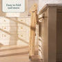 The TP Active-Tots Pikler Style Wooden Folding Helper Tower by TP Toys is FSC® certified and easily folds for storage—shown here propped upright against a kitchen counter in a bright, modern kitchen.