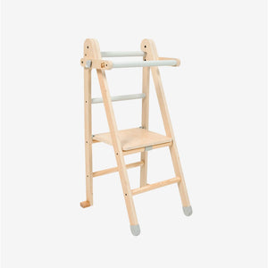 The TP Toys TP Active-Tots Pikler Style Wooden Folding Helper Tower—crafted from FSC® certified wood—features gray accents, two sturdy steps, and safety rails thoughtfully designed for children. Against a plain white background, this stylish kids step stool offers both safety and support for little ones reaching new heights.