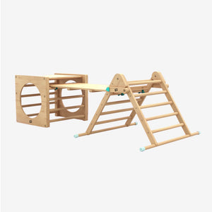 The TP Toys TP Active-Tots Pikler Style Wooden Climbing Triangle, Cube & Slide—crafted from FSC® certified wood—features a climbing triangle, a cube with circular openings, and a connecting balance beam, making it the perfect Montessori-inspired indoor playset for your play area, shown here against a plain white background.
