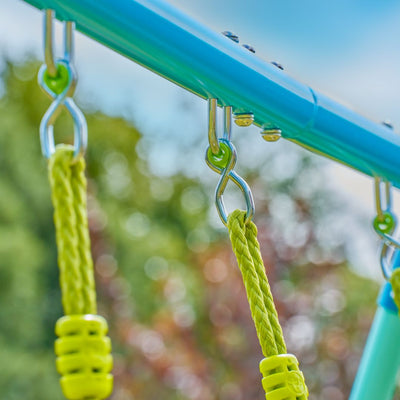Close-up of two yellow swing ropes on the TP Toys TP Double Metal Swing Set's blue powder-coated steel frame, with blurred trees and sky in the background.