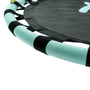 Close-up of a TP Toys TP Giant Nest Metal Swing Set shows a trampoline frame with teal padding and black straps on the jumping surface, placed near the metal swing set for extra backyard fun.