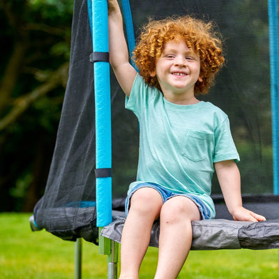 A child bounces joyfully on a TP Toys Up 8ft Trampoline, enjoying safe fun with easy, zip-free entry.