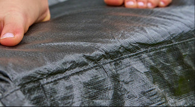 Close-up of a person’s bare feet on the edge of the TP Toys TP Up 14ft Trampoline—ideal for kids to enjoy outdoor fun.
