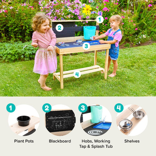 Two young children enjoy outdoor play at the TP Toys TP Little Chef Wooden Mud Kitchen – FSC® certified, featuring plant pots, a blackboard, hobs, a tap, splash tub, and shelves in a blooming garden.