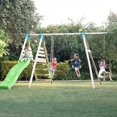 Four children play on the TP Toys TP Knightswood Triple Wooden Swing & Slide Set with Glide Ride & Button Seat in a grassy, tree-lined backyard.